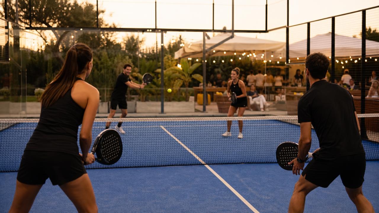 Corporate padel event organised by PadelPump — teams playing doubles at a premium venue